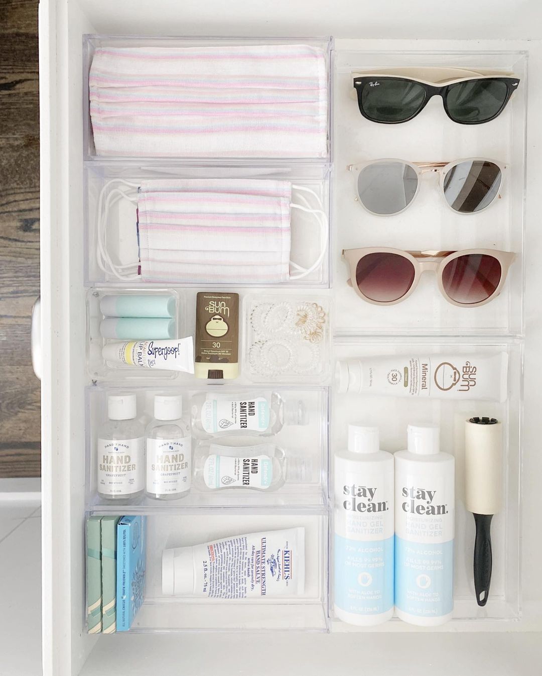 Neat drawer filled with masks, sunglasses and skincare. 