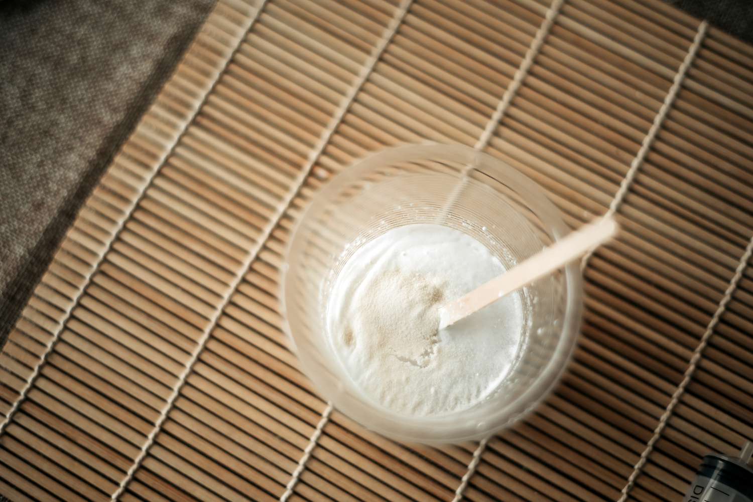 A cup of handmade toothpaste reaches desired consistency on table