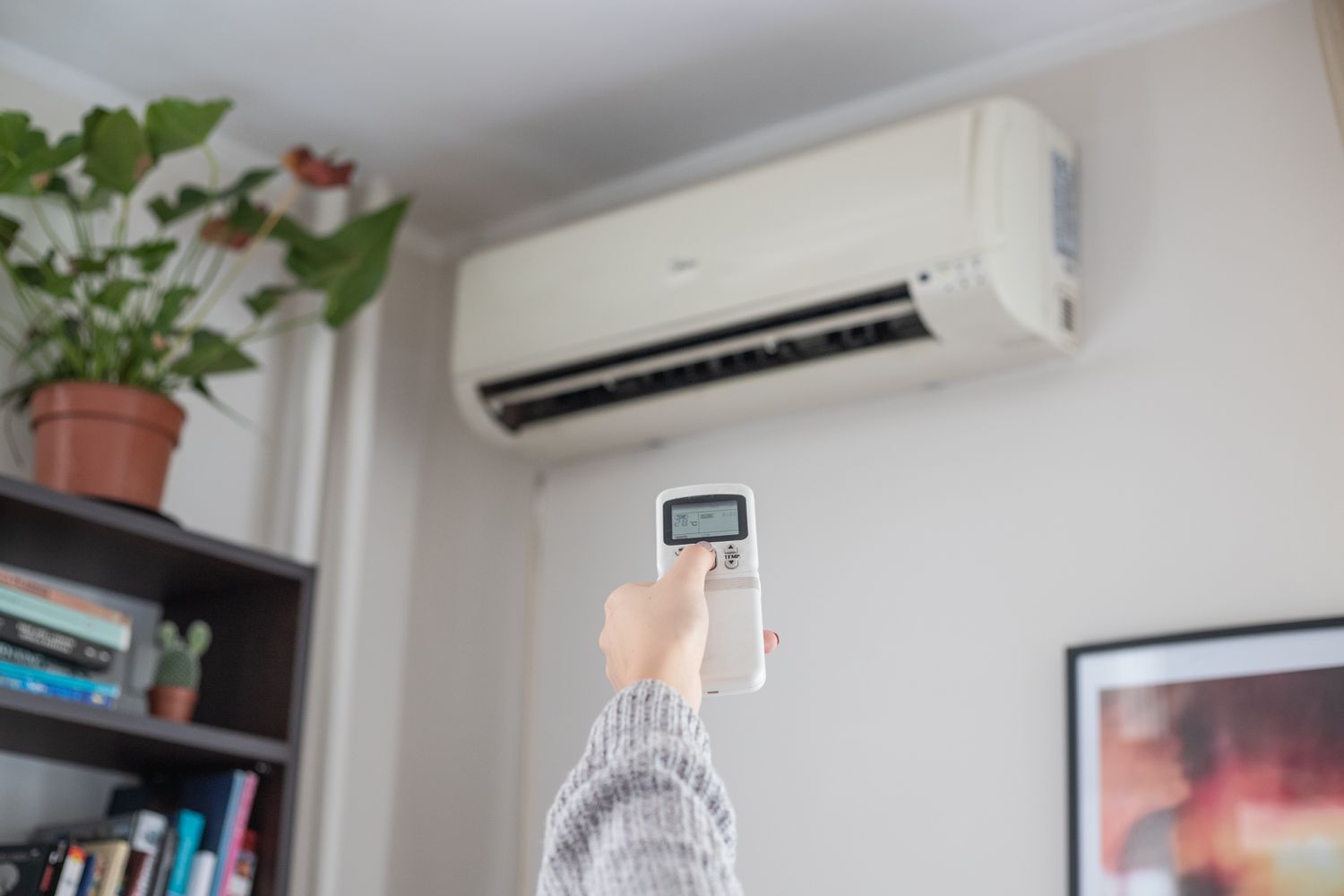 hand turns on air conditioning unit