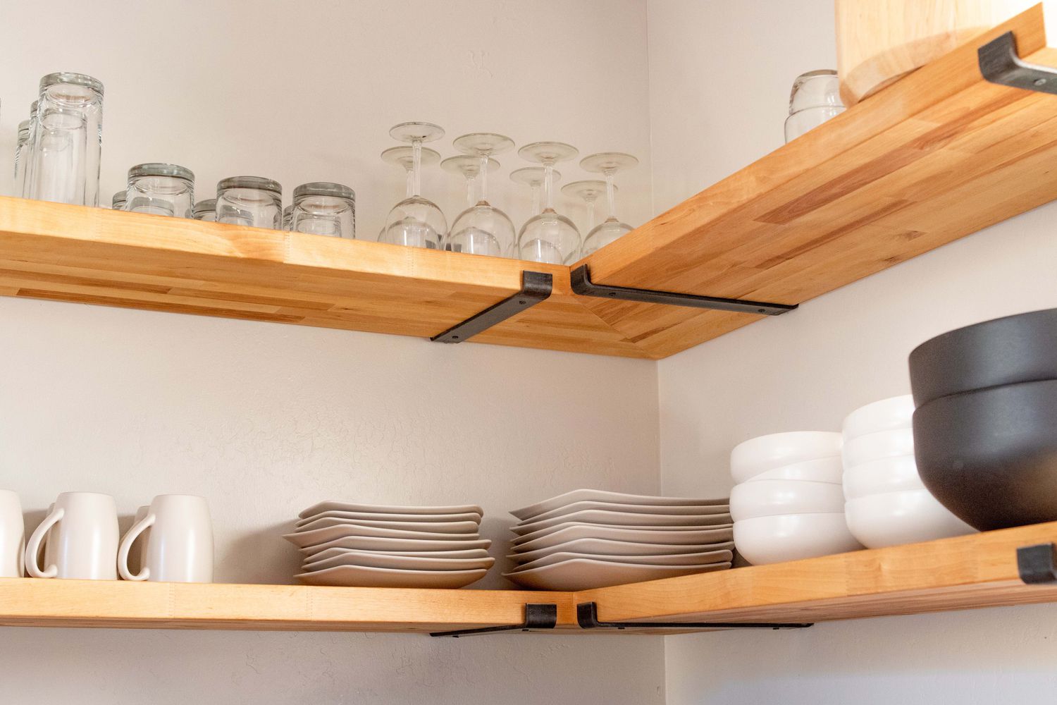 exposed wood shelving with minimalist pottery display in kitchen
