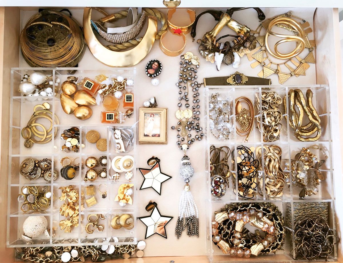 Gold jewelry in organizer bins. 