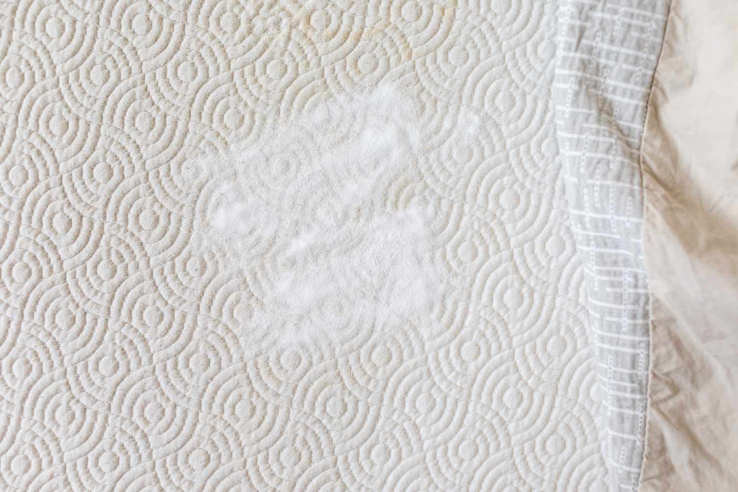 pile of spread-out baking soda on bare mattress with top sheet pulled away