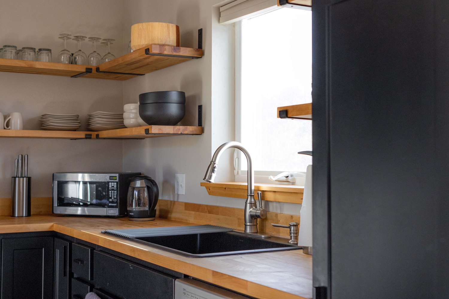 minimalist kitchen with exposed wood shelves and matte black shelves