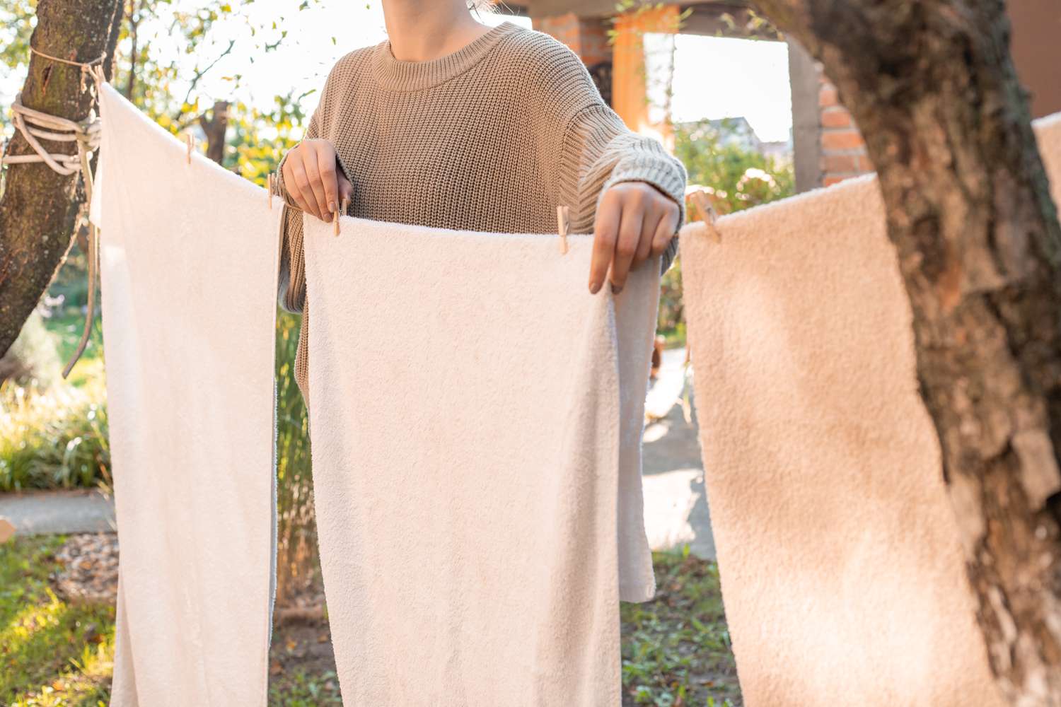 woman hangs up towels outside on line