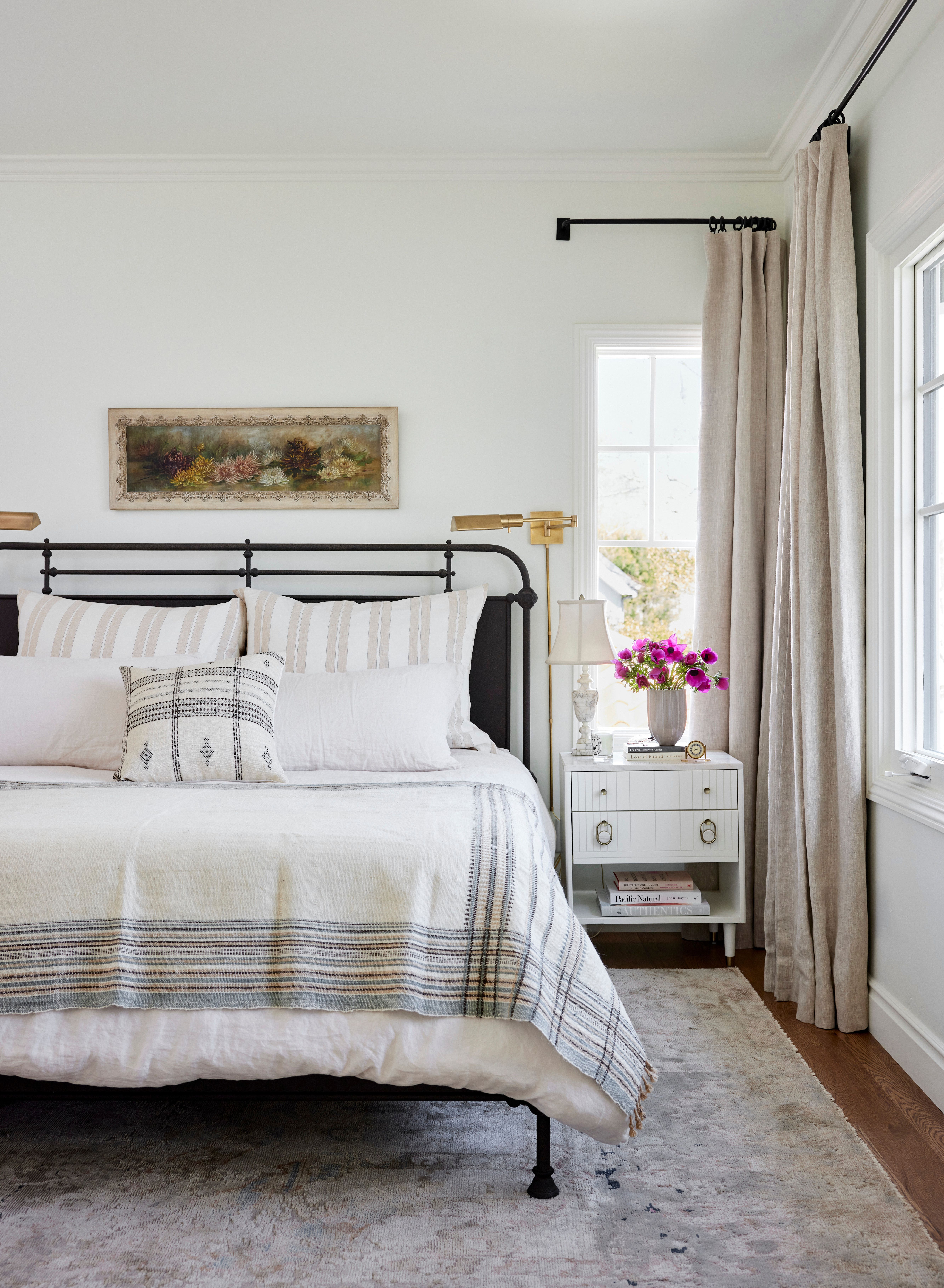 Bedroom with a black bedfram and vintage accents