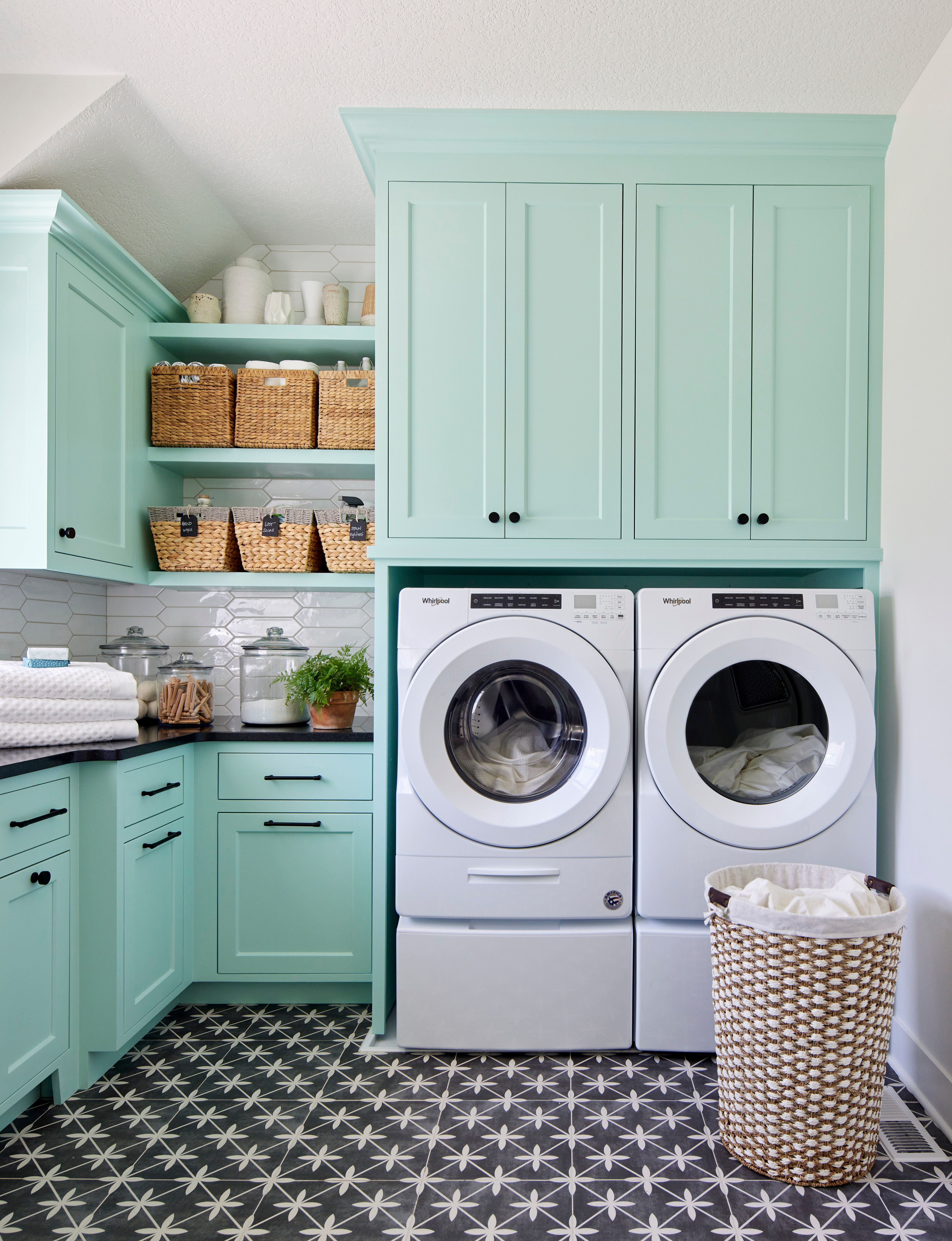Laundry room with teal cabinets and black and white flooring